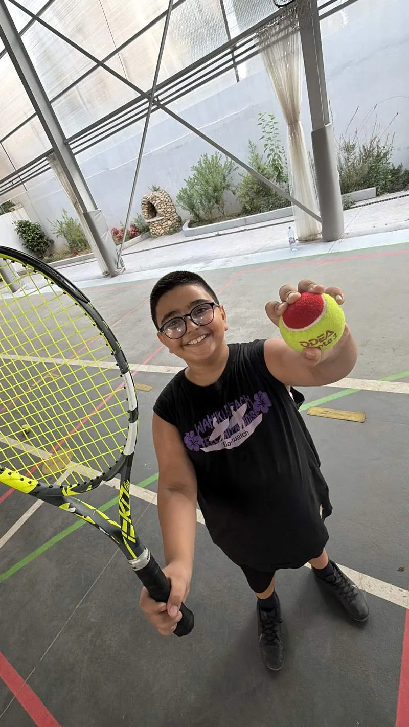 Young player smiling with a red-stage training ball
